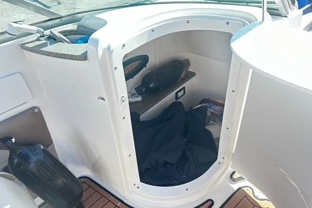 Slide: The Image of 2018 Godfrey Hurricane SD2486 boat storage compartment with various items inside. - 12