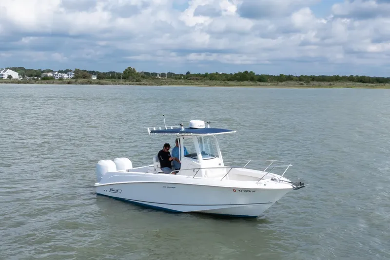 Slide: The Image of 2010 Boston Whaler 250 Outrage boat on calm water under cloudy sky. - 21
