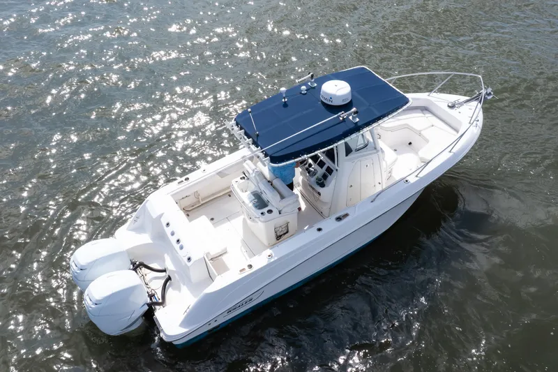 Slide: The Image of 2010 Boston Whaler 250 Outrage boat on water, featuring twin engines and spacious deck. - 24
