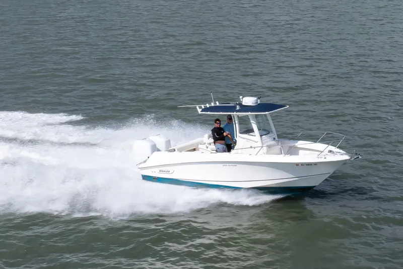 Slide: The Image of 2010 Boston Whaler 250 Outrage speeding on open water, showcasing sleek design and performance. - 4