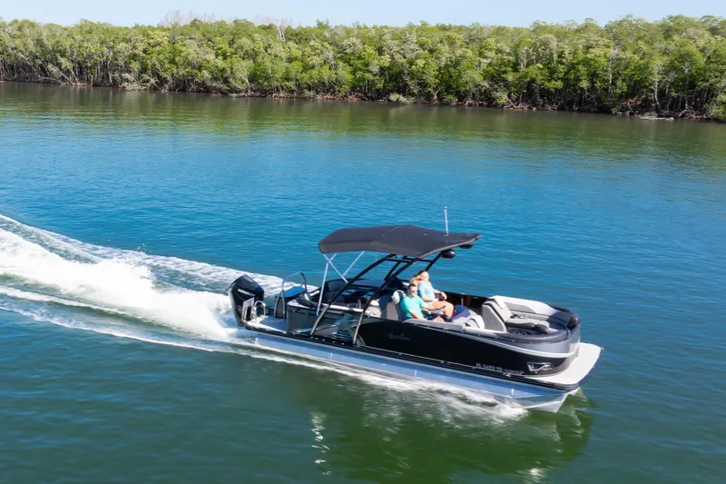 Slide: The Image of 2021 Avalon LSZ Quad Lounger 24' cruising on a serene lake with lush greenery. - 14