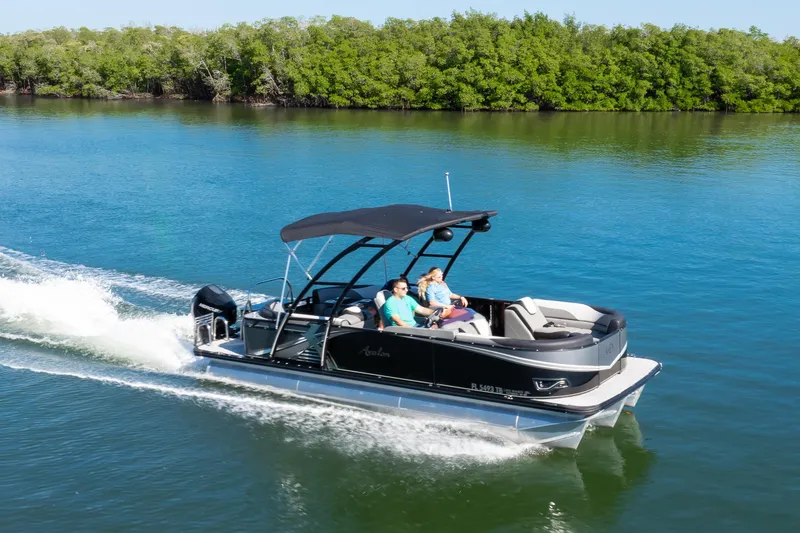 Slide: The Image of 2021 Avalon LSZ Quad Lounger pontoon boat cruising on a serene lake. - 17