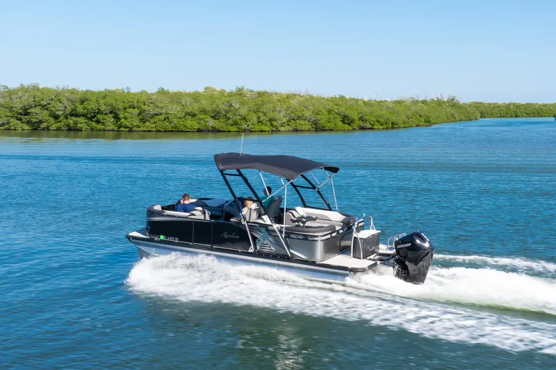 Slide: The Image of 2021 Avalon LSZ Quad Lounger 24' pontoon boat cruising on a scenic waterway. - 22