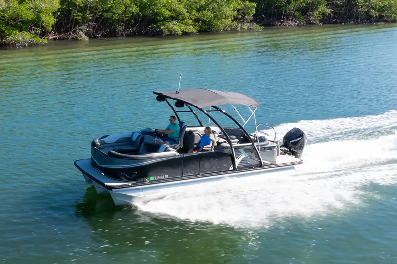 Slide: The Image of 2021 Avalon LSZ Quad Lounger boat cruising on a serene waterway. - 27