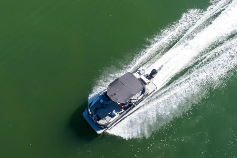 Slide: The Image of Aerial view of 2021 Avalon LSZ Quad Lounger boat cruising on green water. - 28