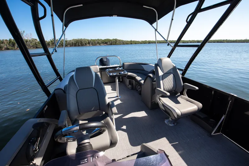 Slide: The Image of 2021 Avalon LSZ Quad Lounger boat interior with comfortable seating on a serene lake. - 31
