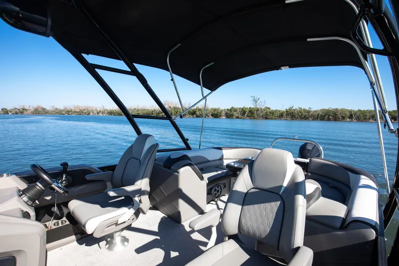 Slide: The Image of 2021 Avalon LSZ Quad Lounger boat interior with comfortable seating on a serene lake. - 33
