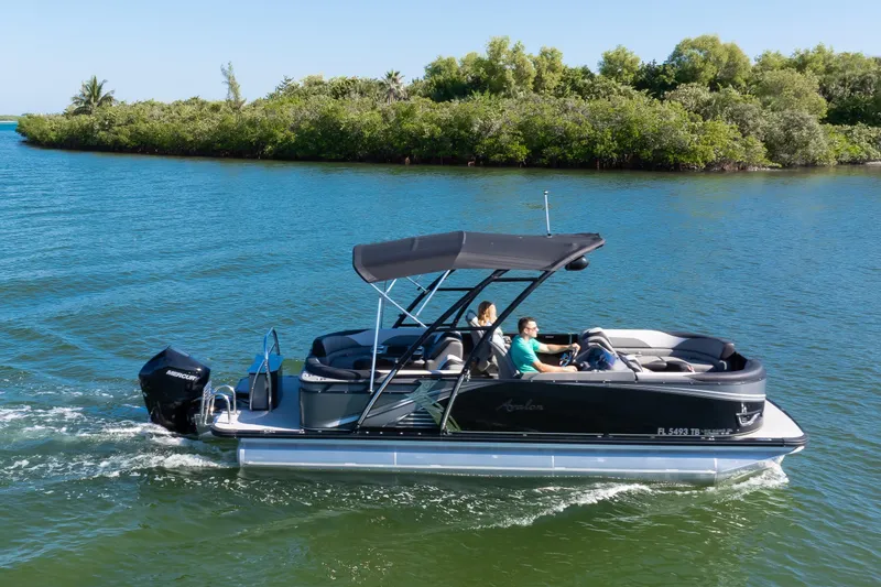 Slide: The Image of 2021 Avalon LSZ Quad Lounger 24' pontoon boat cruising on a scenic waterway. - 4