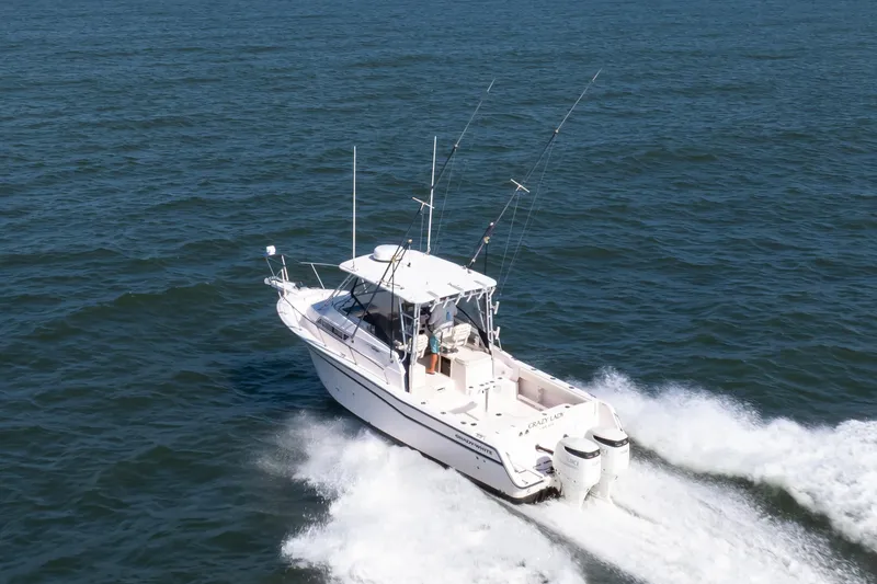 Slide: The Image of 1997 Grady-White Marlin 300 boat cruising on open water with fishing rods. - 22