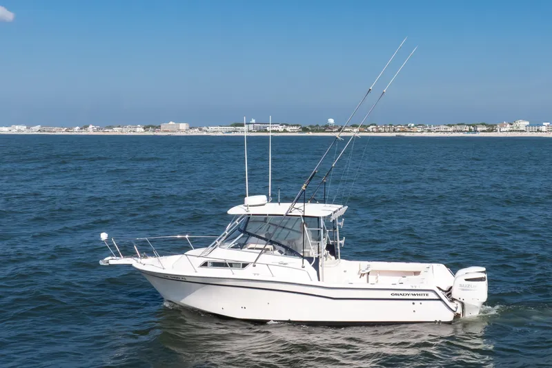 Slide: The Image of 1997 Grady-White Marlin 300 boat on ocean with coastal background. - 26