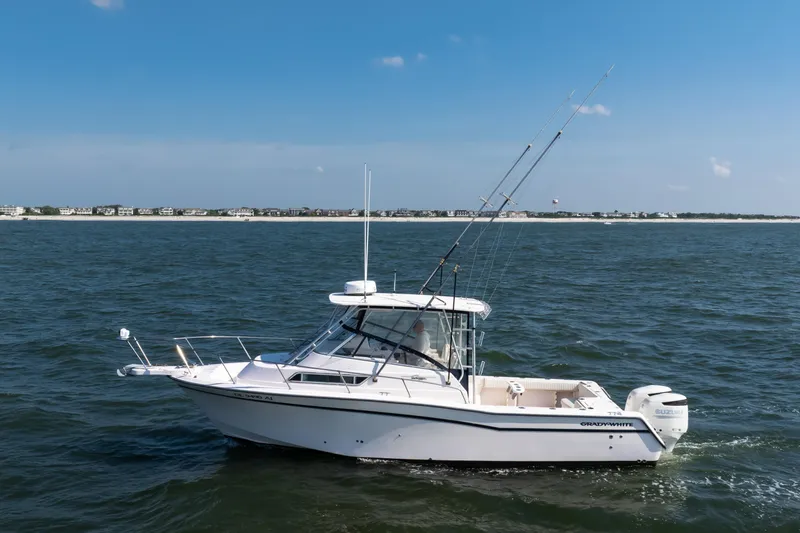 Slide: The Image of 1997 Grady-White Marlin 300 boat on open water, clear sky background. - 30