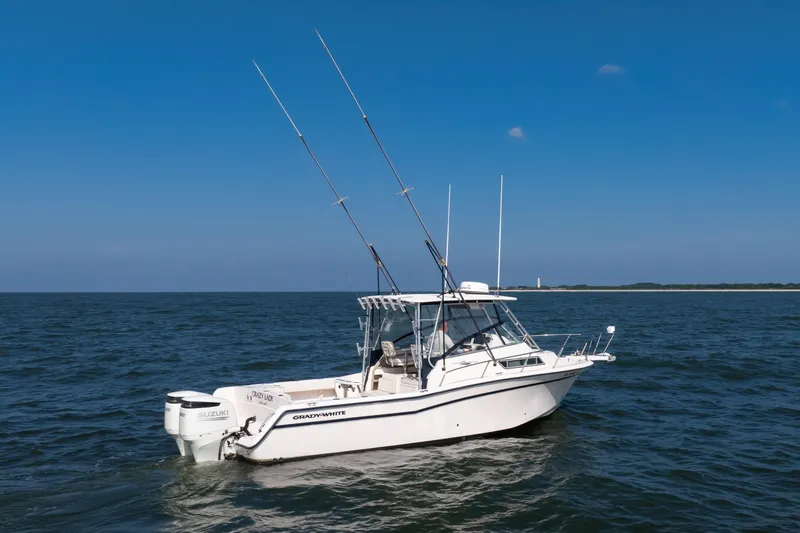 Slide: The Image of 1997 Grady-White Marlin 300 boat on open water under clear blue sky. - 33