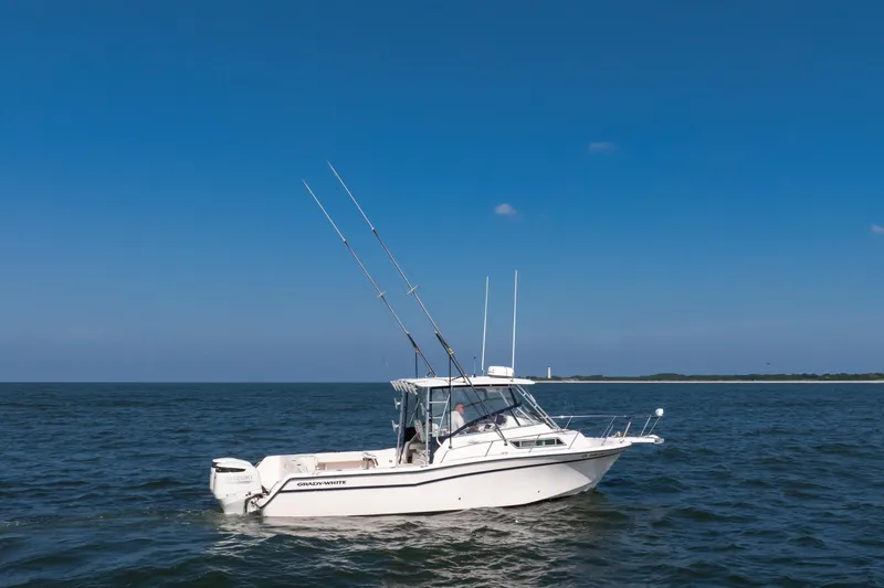 Slide: The Image of 1997 Grady-White Marlin 300 boat on open water under clear blue sky. - 35