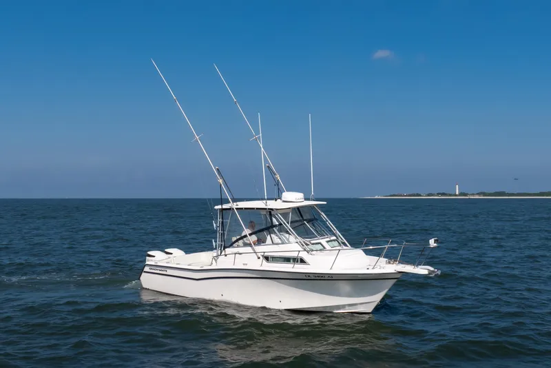 Slide: The Image of 1997 Grady-White Marlin 300 boat cruising on open water under clear blue sky. - 42