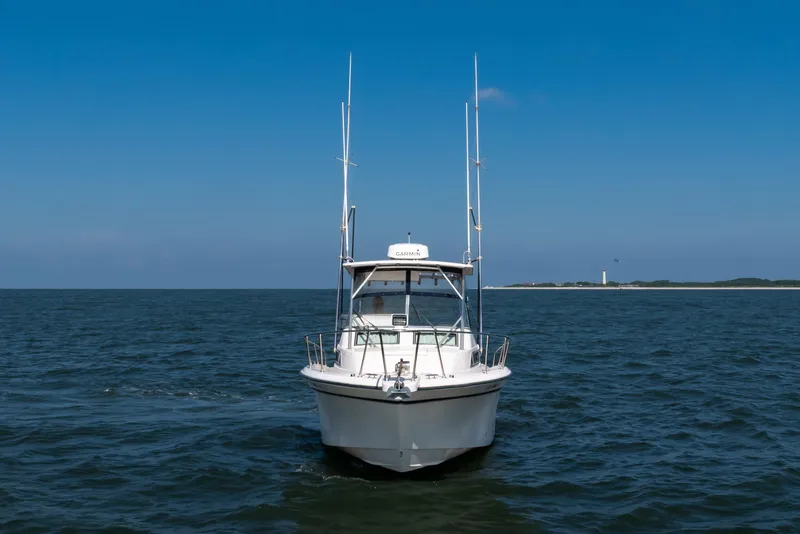 Slide: The Image of 1997 Grady-White Marlin 300 boat on open water under clear blue sky. - 44