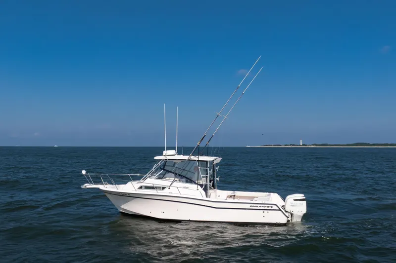 Slide: The Image of 1997 Grady-White Marlin 300 boat on open water under clear blue sky. - 45