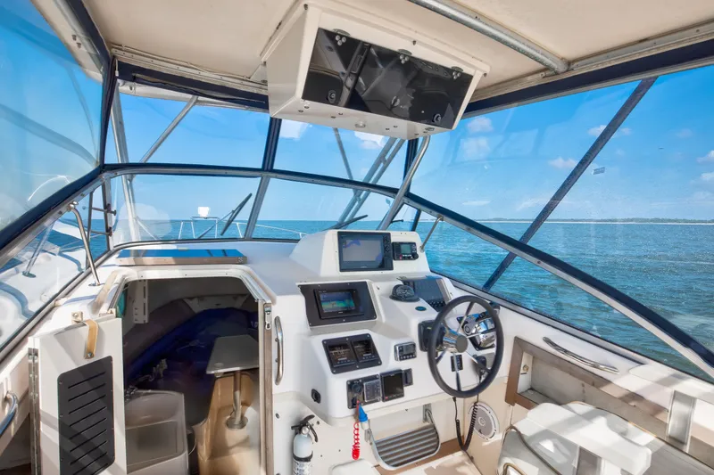 Slide: The Image of 1997 Grady-White Marlin 300 boat interior with helm, steering wheel, and ocean view. - 48