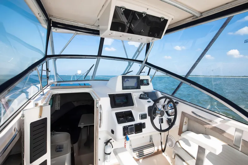 Slide: The Image of 1997 Grady-White Marlin 300 boat cockpit with steering wheel and navigation equipment. - 50