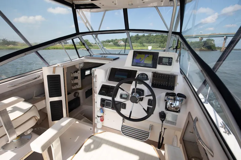 Slide: The Image of 1997 Grady-White Marlin 300 boat cockpit with steering wheel and navigation equipment. - 59