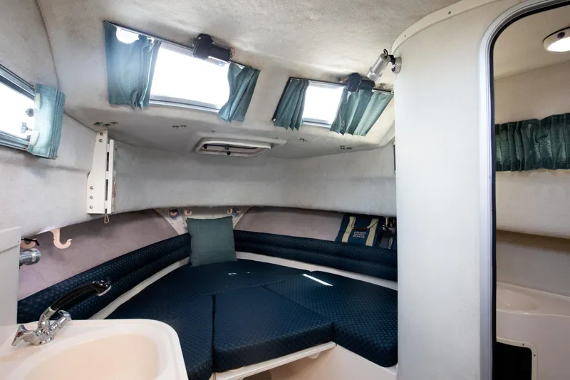Slide: The Image of 1997 Grady-White Marlin 300 cabin interior with blue seating and natural light. - 60
