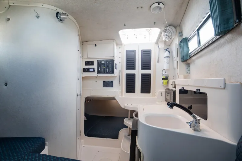 Slide: The Image of Interior of 1997 Grady-White Marlin 300 boat, featuring a compact cabin with sink and seating. - 66