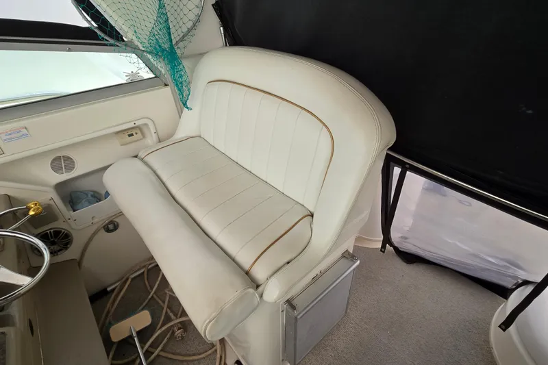 Slide: The Image of Interior seating of 1998 Sea Ray 340 Amberjack boat, featuring white upholstery and steering wheel. - 12
