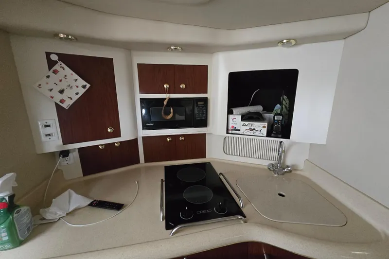Slide: The Image of 1998 Sea Ray 340 Amberjack kitchen with stove, microwave, and sink. - 21