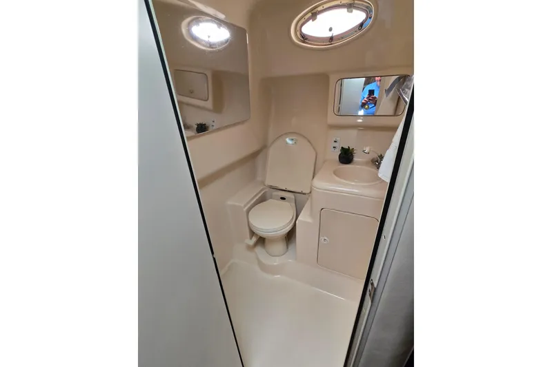 Slide: The Image of 1998 Sea Ray 340 Amberjack boat bathroom with toilet, sink, and mirror. - 24