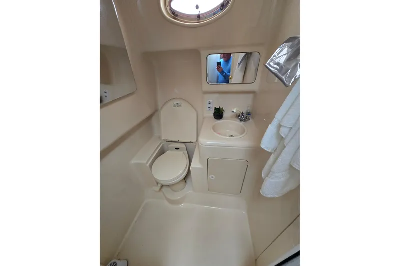 Slide: The Image of 1998 Sea Ray 340 Amberjack bathroom with toilet, sink, mirror, and towels. - 25