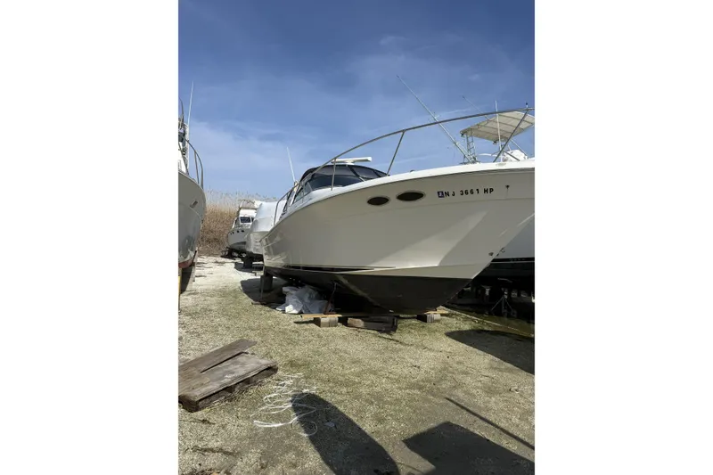 Slide: The Image of 1998 Sea Ray 330 Express boat on dry dock under clear blue sky. - 4