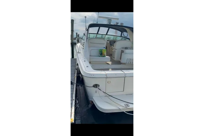 Slide: The Image of 1998 Sea Ray 340 Amberjack docked, showcasing spacious deck and seating area. - 8