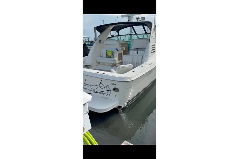 Slide: The Image of 1998 Sea Ray 340 Amberjack docked, rear view, with open cockpit and visible seating. - 9