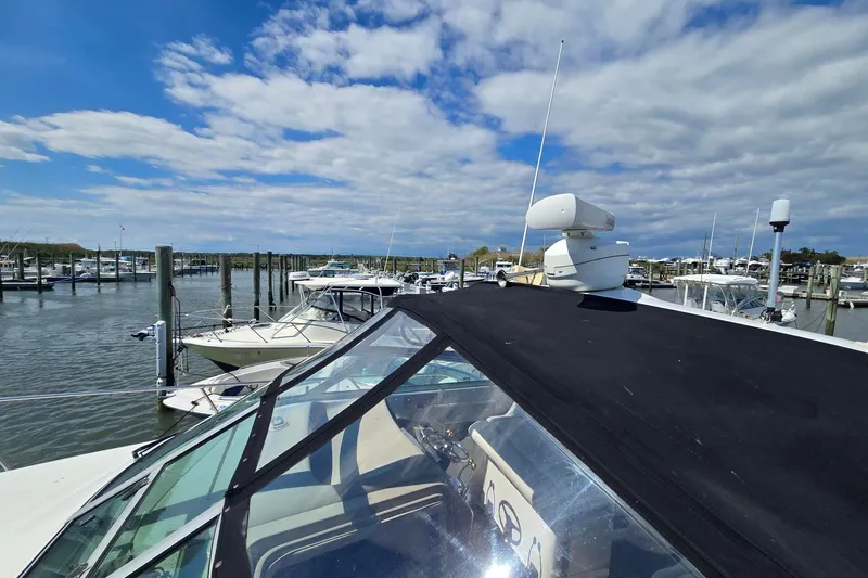 Slide: The Image of 1998 Sea Ray 330 Express docked at a marina under a partly cloudy sky. - 14