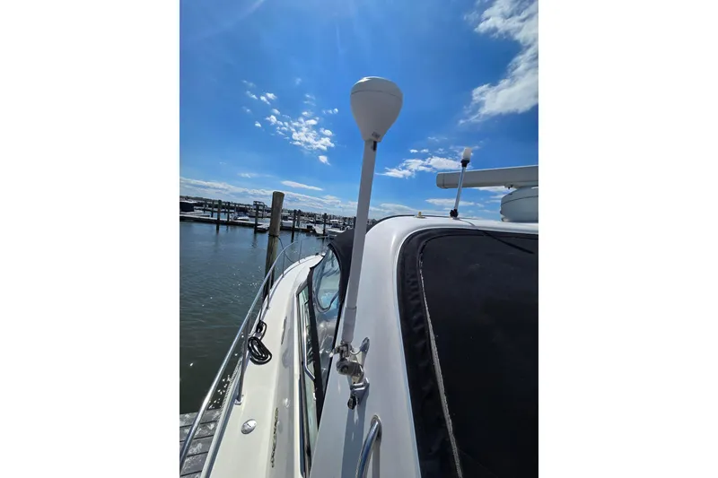 Slide: The Image of 1998 Sea Ray 330 Express yacht docked under a clear blue sky. - 16
