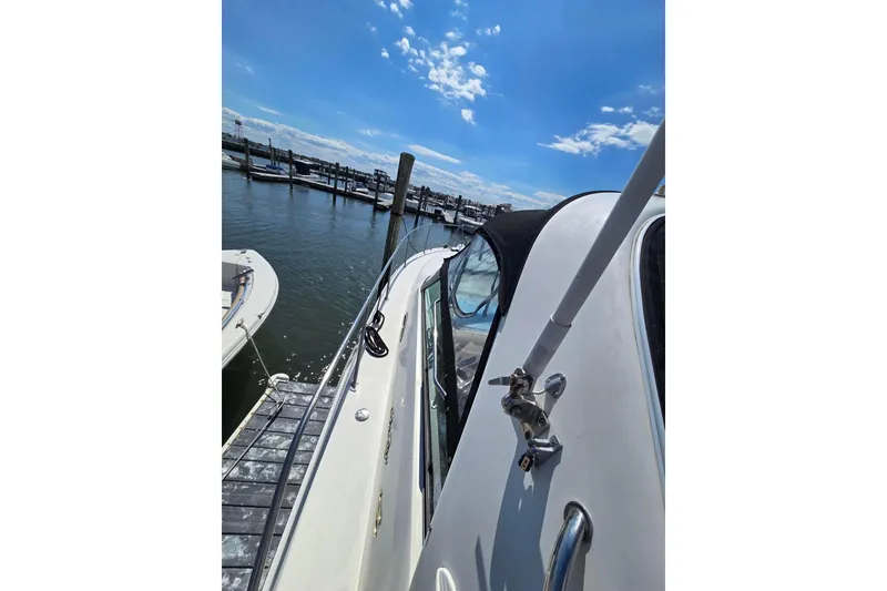 Slide: The Image of 1998 Sea Ray 330 Express docked at marina under clear blue sky. - 17
