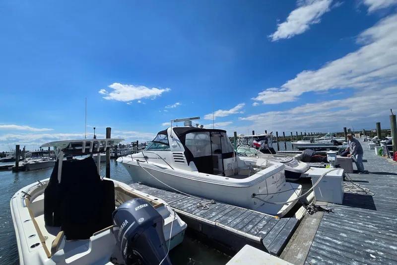 Slide: The Image of 1998 Sea Ray 330 Express docked at marina under clear blue sky. - 2