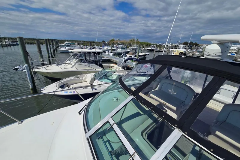 Slide: The Image of 1998 Sea Ray 340 Amberjack interior seating with white upholstery and storage area. - 23