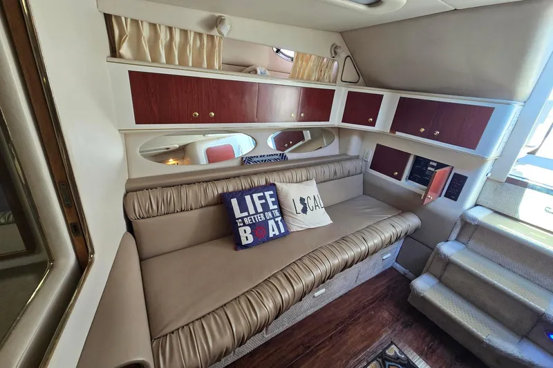 Slide: The Image of 1998 Sea Ray 330 Express cabin interior with sofa, pillows, and wooden cabinets. - 26