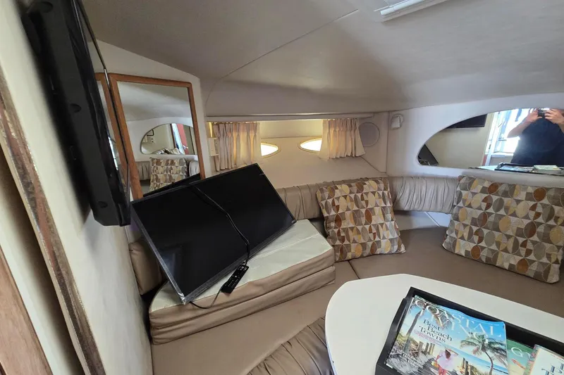 Slide: The Image of Interior of a 1998 Sea Ray 330 Express with cozy seating and a mounted TV. - 28