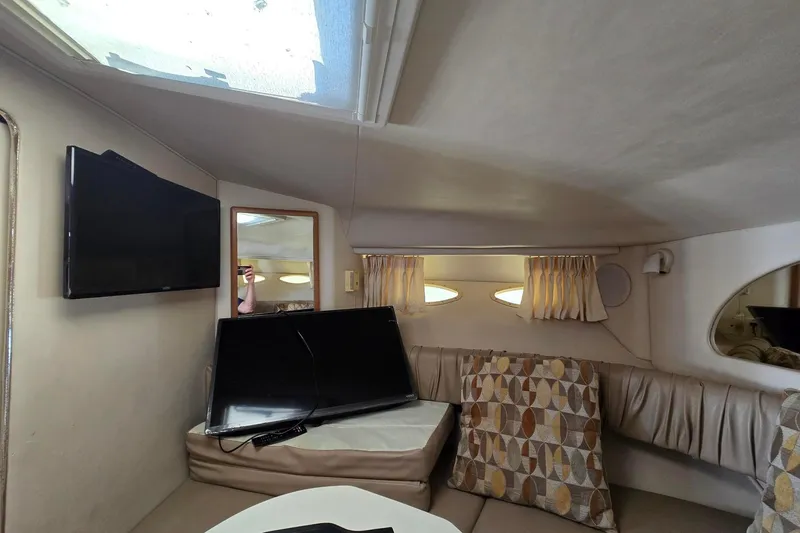 Slide: The Image of Interior of 1998 Sea Ray 330 Express with cozy seating, TV, and patterned cushions. - 29