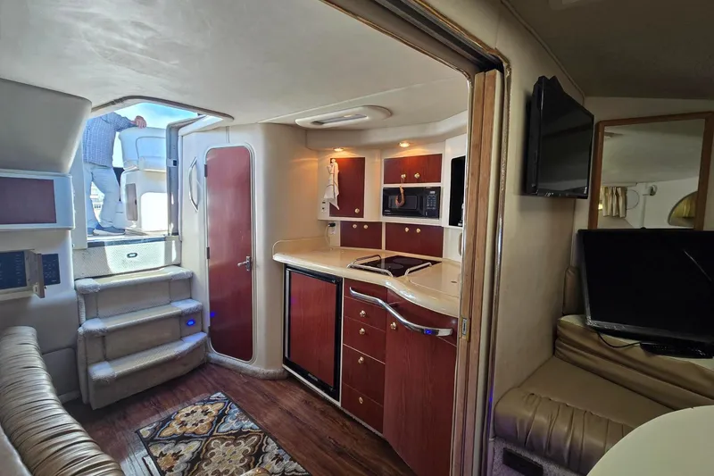 Slide: The Image of Interior of 1998 Sea Ray 330 Express boat with kitchenette and seating area. - 30