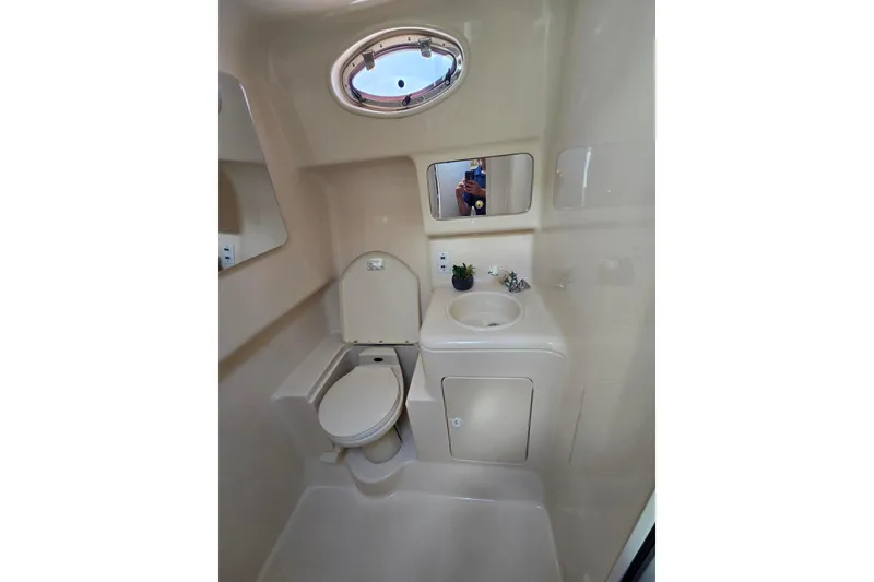 Slide: The Image of 1998 Sea Ray 330 Express boat bathroom with toilet, sink, and mirror. - 31