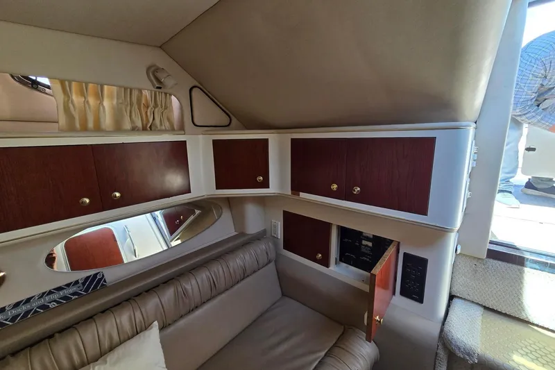 Slide: The Image of Interior of 1998 Sea Ray 330 Express boat with wood cabinets and beige seating. - 34