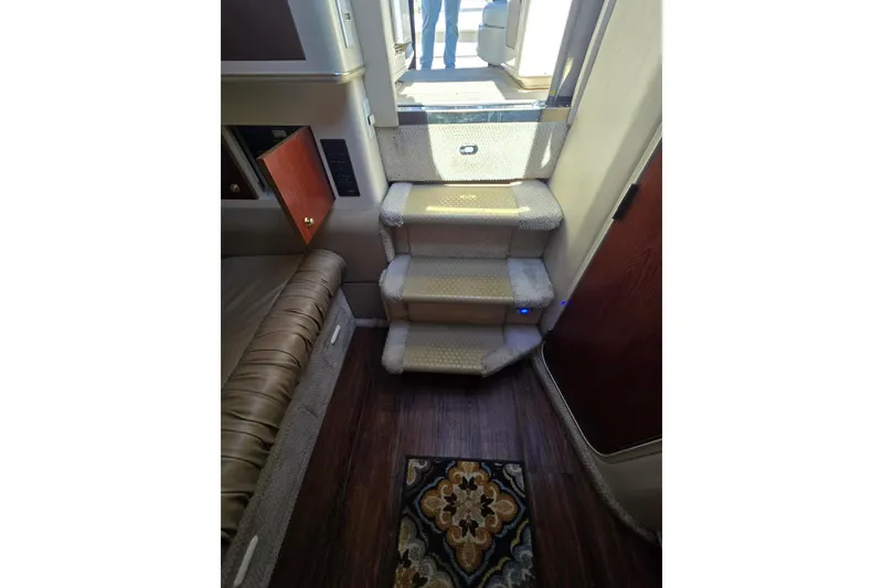 Slide: The Image of Interior stairs of 1998 Sea Ray 330 Express yacht, featuring carpeted steps and wood flooring. - 36