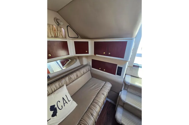 Slide: The Image of Interior of 1998 Sea Ray 330 Express with beige seating, wooden cabinets, and stairs. - 37