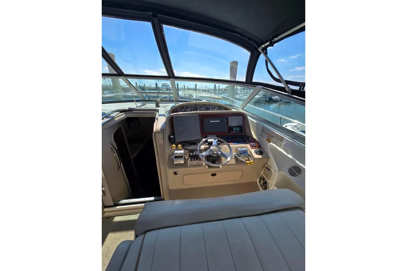 Slide: The Image of 1998 Sea Ray 330 Express helm with modern navigation equipment and waterfront view. - 38
