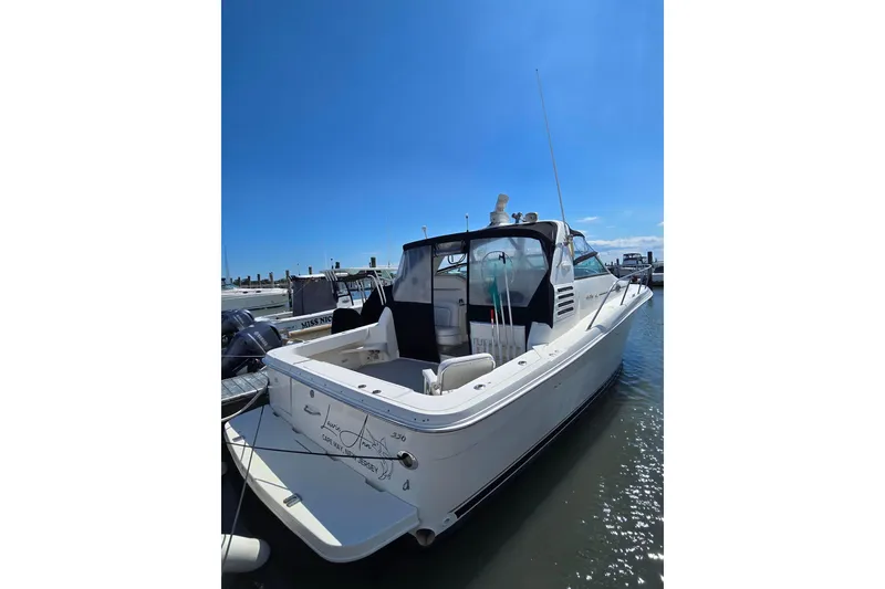Slide: The Image of 1998 Sea Ray 330 Express boat docked in marina under clear blue sky. - 4