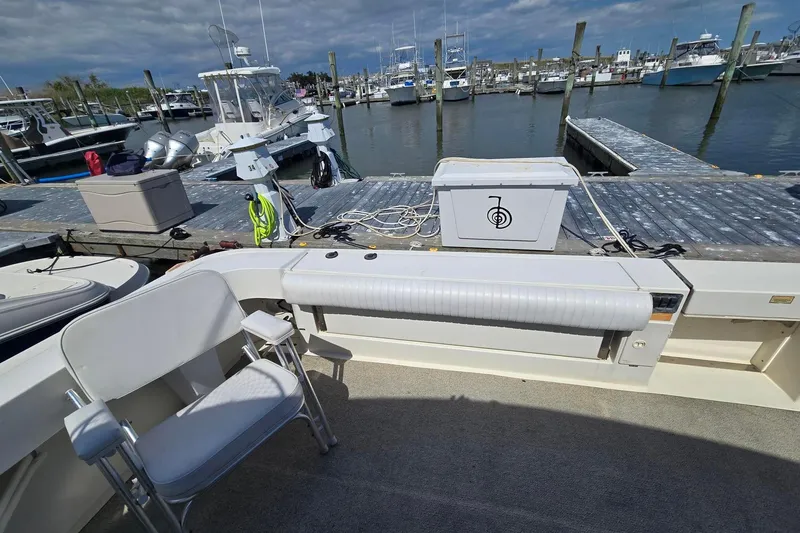 Slide: The Image of 1998 Sea Ray 330 Express at marina, featuring dockside view and seating area. - 41