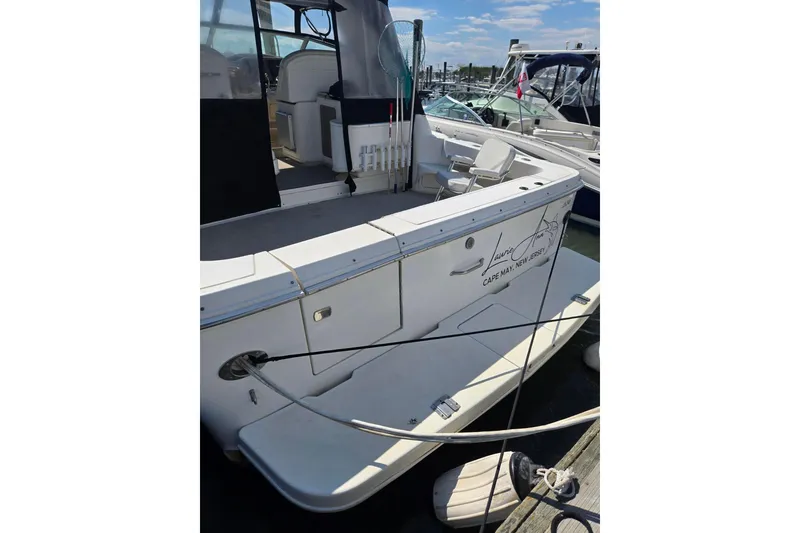 Slide: The Image of 1998 Sea Ray 330 Express boat docked, featuring spacious deck and seating area. - 5