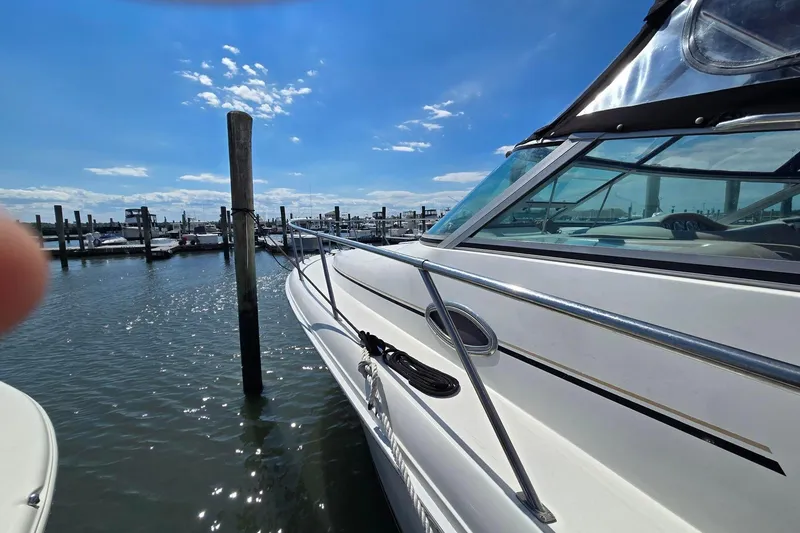 Slide: The Image of 1998 Sea Ray 330 Express yacht docked at marina under clear blue sky. - 8